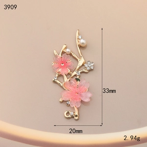 Detailed macro view of cherry blossom pendant with gold alloy, resin and white pearls