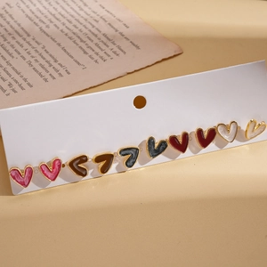 Ten-piece set of minimalist heart stud earrings in five colors on a vintage paper display