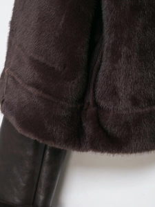 Detail of dark chocolate faux fur coat showing smooth texture and leather trim