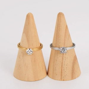 Frosted couple rings with round zircon in gold and silver finish on wooden display