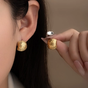 Minimalist gold geometric titanium steel earrings with textured finish on model