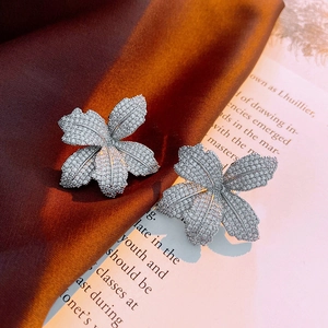 Macro view of flower-shaped stud earrings with micro-pave crystals on silver metal
