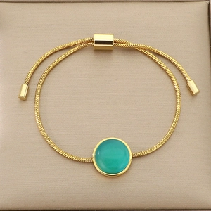Détail d'un bracelet chaîne serpent dorée ajustable avec une pierre naturelle verte