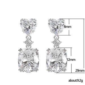 Three-tier silver drop earrings with heart and cushion-cut stones and dimension details