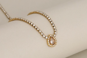 Close-up of luxury gold-plated necklace featuring a water-drop pendant with full pavé diamonds