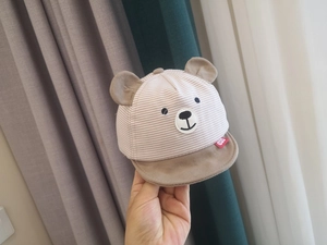 Detailed macro view of soft striped infant sun hat with cute 3D bear ears and embroidery