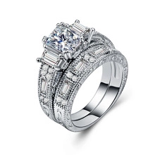 Detail of vintage engraved wedding ring set with oval cubic zirconia and milgrain edges