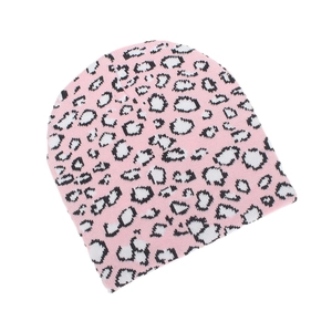 Close-up of pink leopard print knit beanie with black and white spots on white background