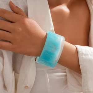 Detail of light blue marble resin bangle showing smooth texture on woman wrist
