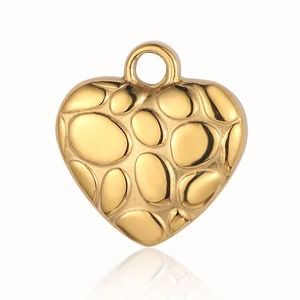 Macro shot of gold heart pendant with unique hammered relief texture on white background