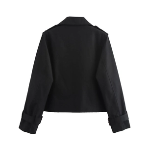 Détail de la veste courte noire montrant les épaulettes et les sangles aux poignets