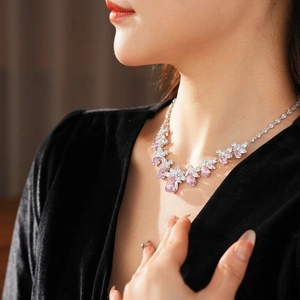 Détail d'un collier avec pendentifs fleurs en zircon rose et blanc porté par un mannequin