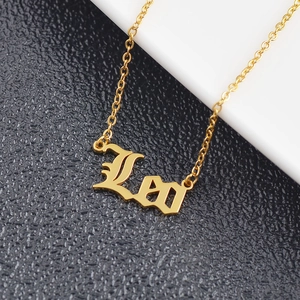 Detail of gold Leo zodiac pendant necklace on polished link chain with macro metal texture
