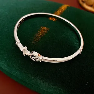Silver-plated arrow cross cuff bracelet with zircon stones on green velvet