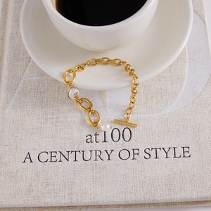 Détail macro du bracelet doré avec perles d'eau douce, fermoir OT et perles à motif floral
