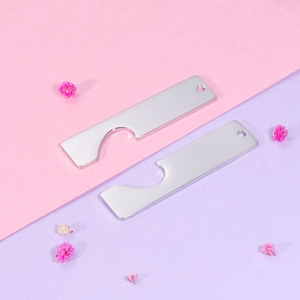 Close-up of dual stainless steel bar pendants with hollow heart cutouts on a floral background