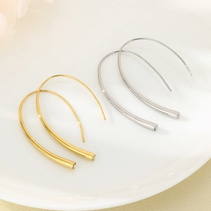 Close-up of gold and silver U-shaped metal hook earrings with crystal embellishments