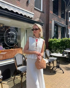 Detailed texture of white pleated sleeveless top and maxi skirt in breathable cotton linen