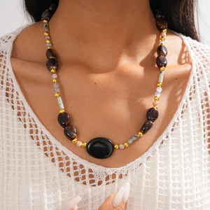 Bohemian style beaded necklace with acrylic stones and gold spacers on a model neck