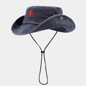 Detail of blue denim sun hat featuring red maple leaf embroidery and brass side snaps