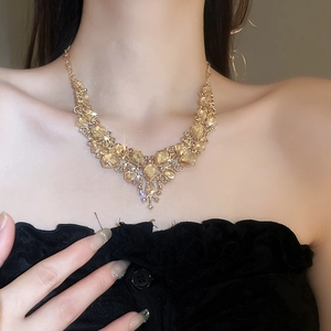 Close-up of model wearing a gold necklace set with champagne teardrop gemstones