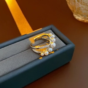Close-up of adjustable silver ring with white pearls and sparkling cubic zirconia details