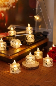 Close-up of diamond-textured LED candle light emitting warm glow on a wooden table