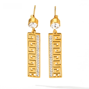 Detail of gold geometric earrings with Greek key pattern and sparkling zircons