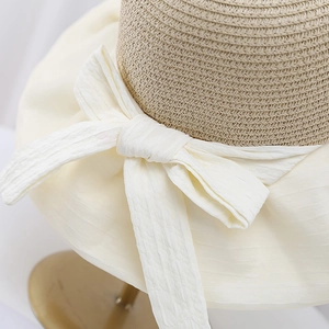 Elegant hollow knit sun hat for women with a beige bow, perfect for UV protection outdoors