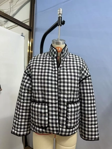 Detail of checkered quilted jacket with stand collar and large front pockets