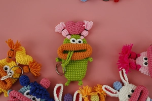 Detail of colorful hand-knitted sausage mouth key case and crochet monster accessory