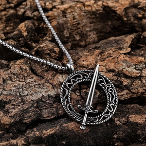 Vintage stainless steel sword and ring pendant necklace with Norse runes on bark backdrop
