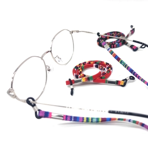 Ethnic woven eyeglass strap with colorful pattern and metal clips on white background