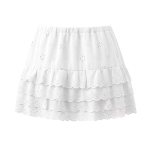 Détails de la jupe blanche à plusieurs couches avec broderies florales et volants