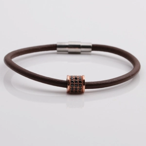 Close-up of brown leather bracelet with rose gold zircon beads and magnetic metal clasp