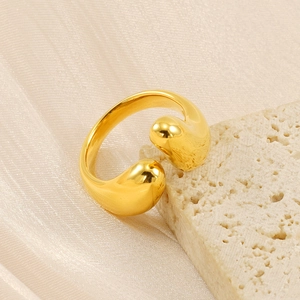 Close-up of teardrop-shaped adjustable gold ring on natural stone and silk fabric