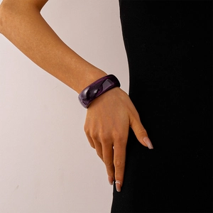 Nahaufnahme eines breiten dunkelvioletten Acryl-Armreifs mit polierter Oberfläche im Vintage-Stil