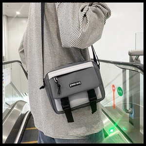 Detail of grey and white retro messenger bag with adjustable strap and buckle closure
