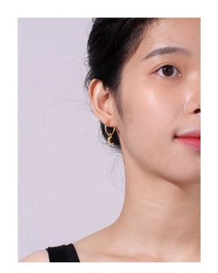 Close-up of model wearing gold crescent moon earrings with cubic zirconia detail