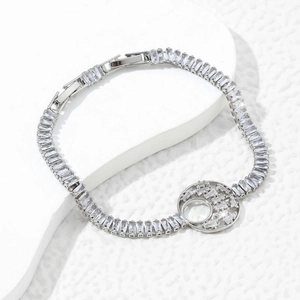 Silver bracelet with rectangular zircons and a round moon cutout on a white marble background
