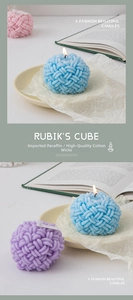 Detail of woven ball scented candles in blue, purple, and pink on a ceramic tray