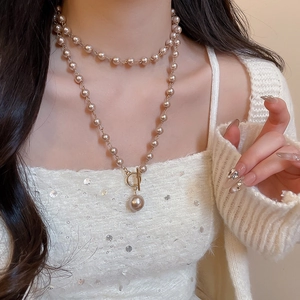 Détail d'un collier de perles double épaisseur avec fermoir toggle OT sur un mannequin
