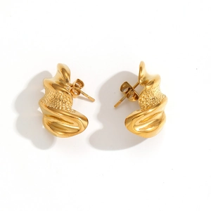 Détail macro de boucles d'oreilles dorées avec texture fondue et éclat métallique