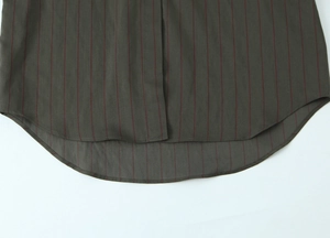 Detail of curved hi-low hem on vertical striped loose shirt in dark olive green