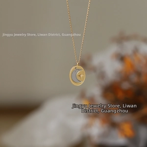 Macro detail of oval moon and star pendant on 18K gold plated stainless steel chain