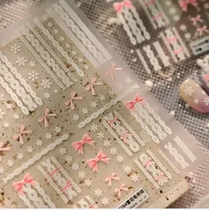 Macro shot of 3D embossed snowflake and sweater texture nail art stickers in pink and white
