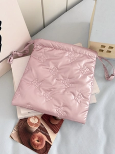 Detailed view of pink quilted bow patterns on waterproof drawstring makeup storage bag