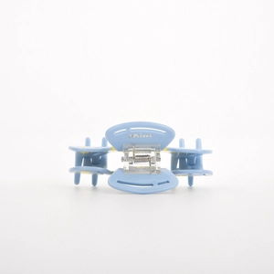 Detail showing sky blue acetate hair claw with silver Kiwi logo and polished finish