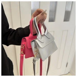 Nahaufnahme kleiner Handtaschen in Silber und Rosarot mit passenden Schultergurten