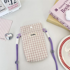 Detailed shot of plaid phone pouch with adjustable rope strap and snap button closure